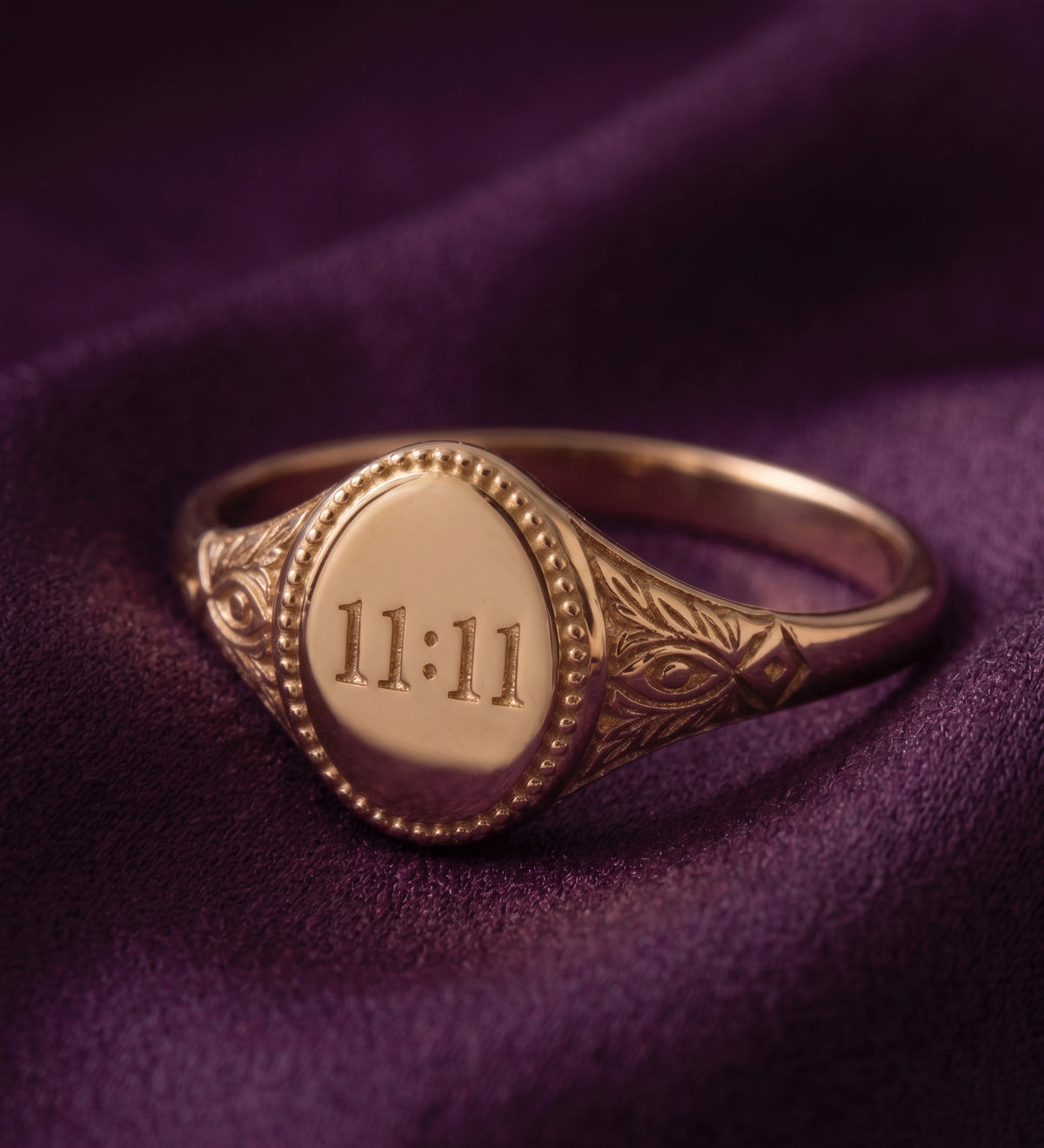 11:11 signet ring on purple velvet, angled view showing the engraved shoulder