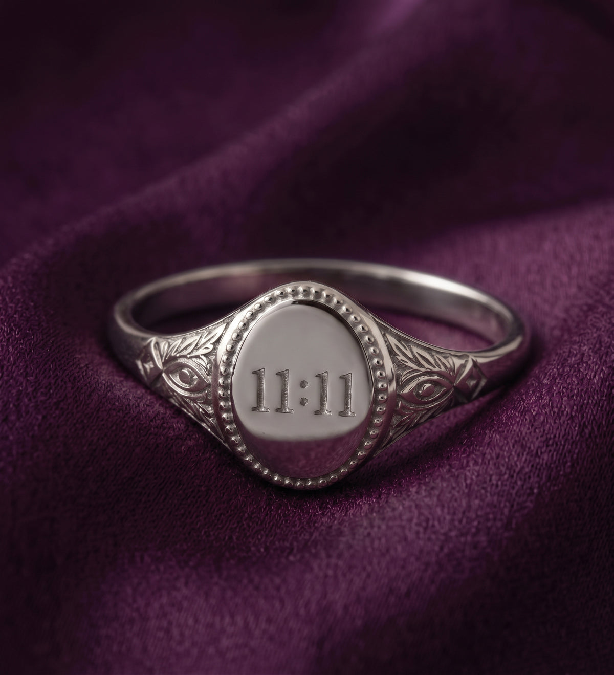 Silver tone 11:11 signet ring on purple velvet
