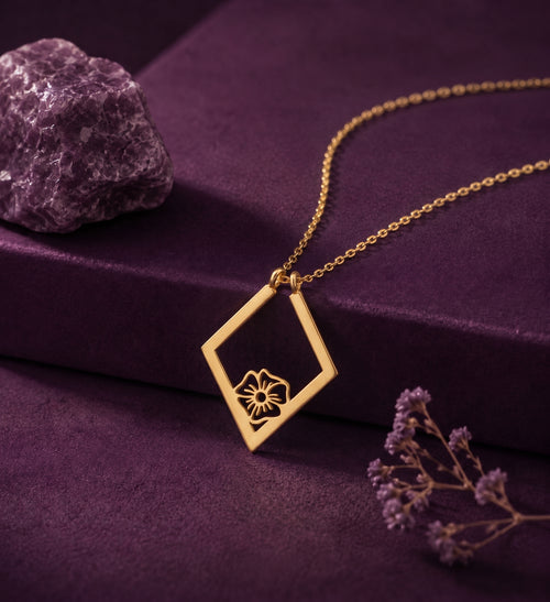 Birth flower ring holder necklace on a plum box beside an amethyst stone