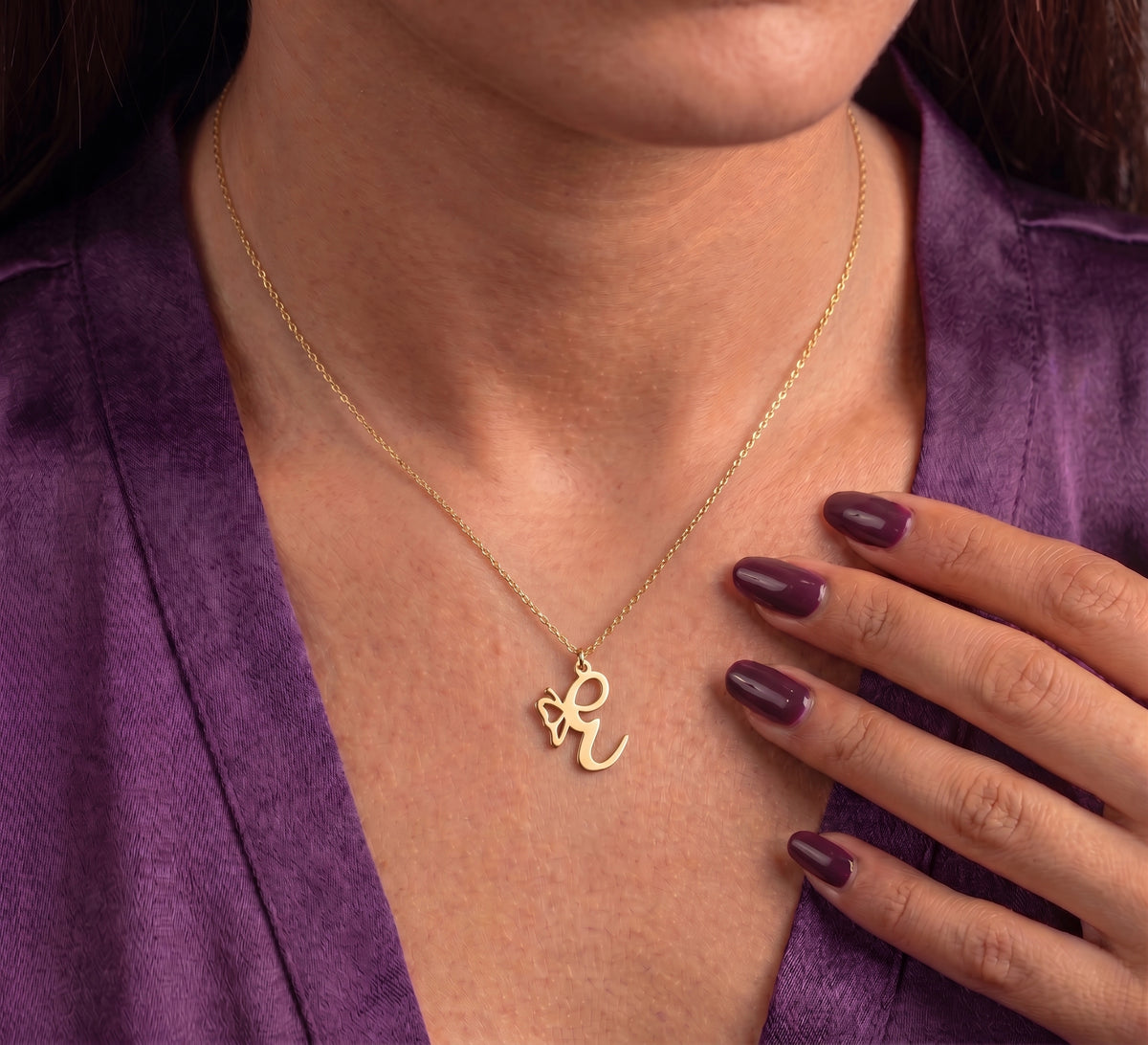 Butterfly initial necklace worn at the collarbone