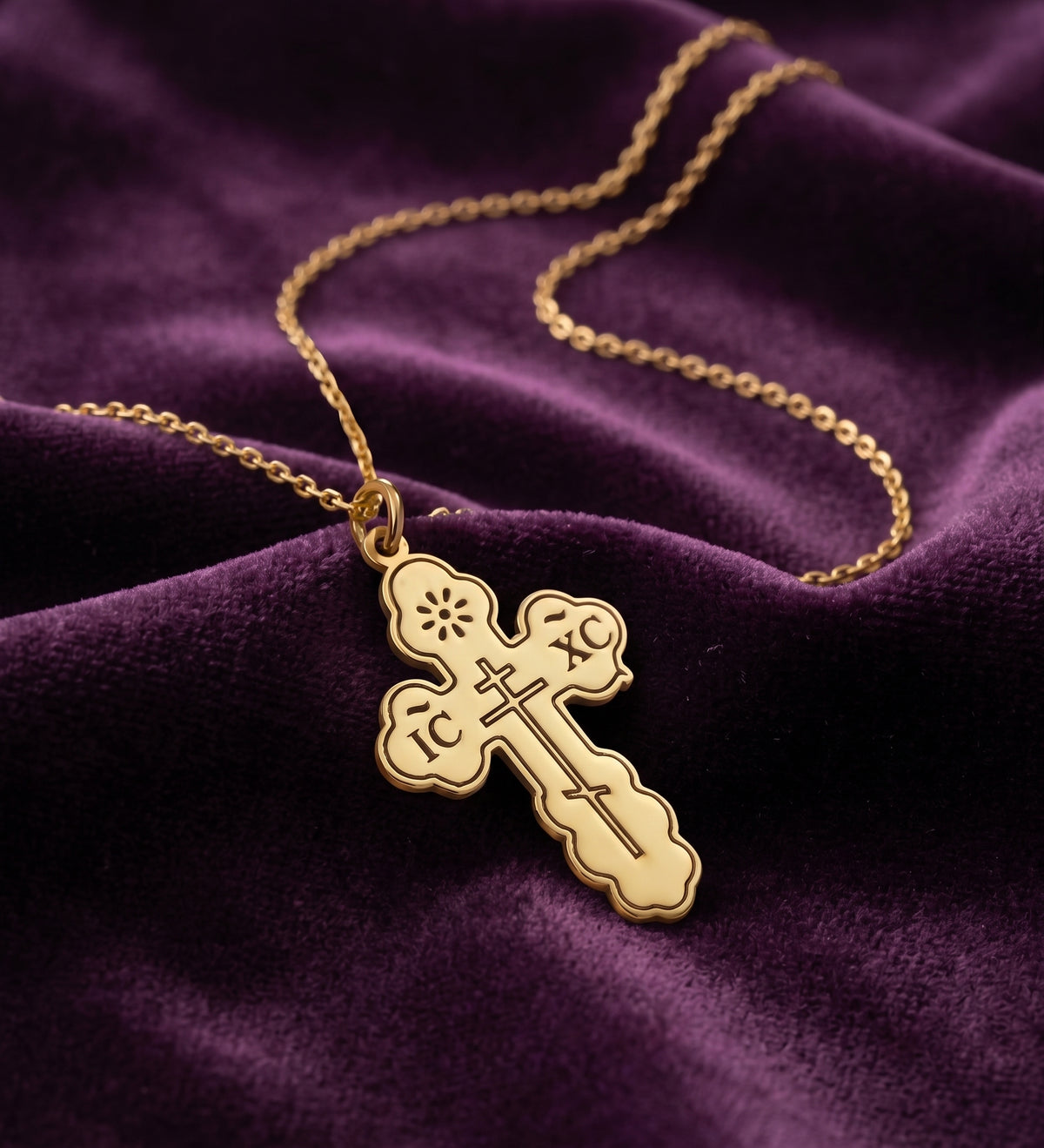Close-up of the engraved cross pendant on purple velvet