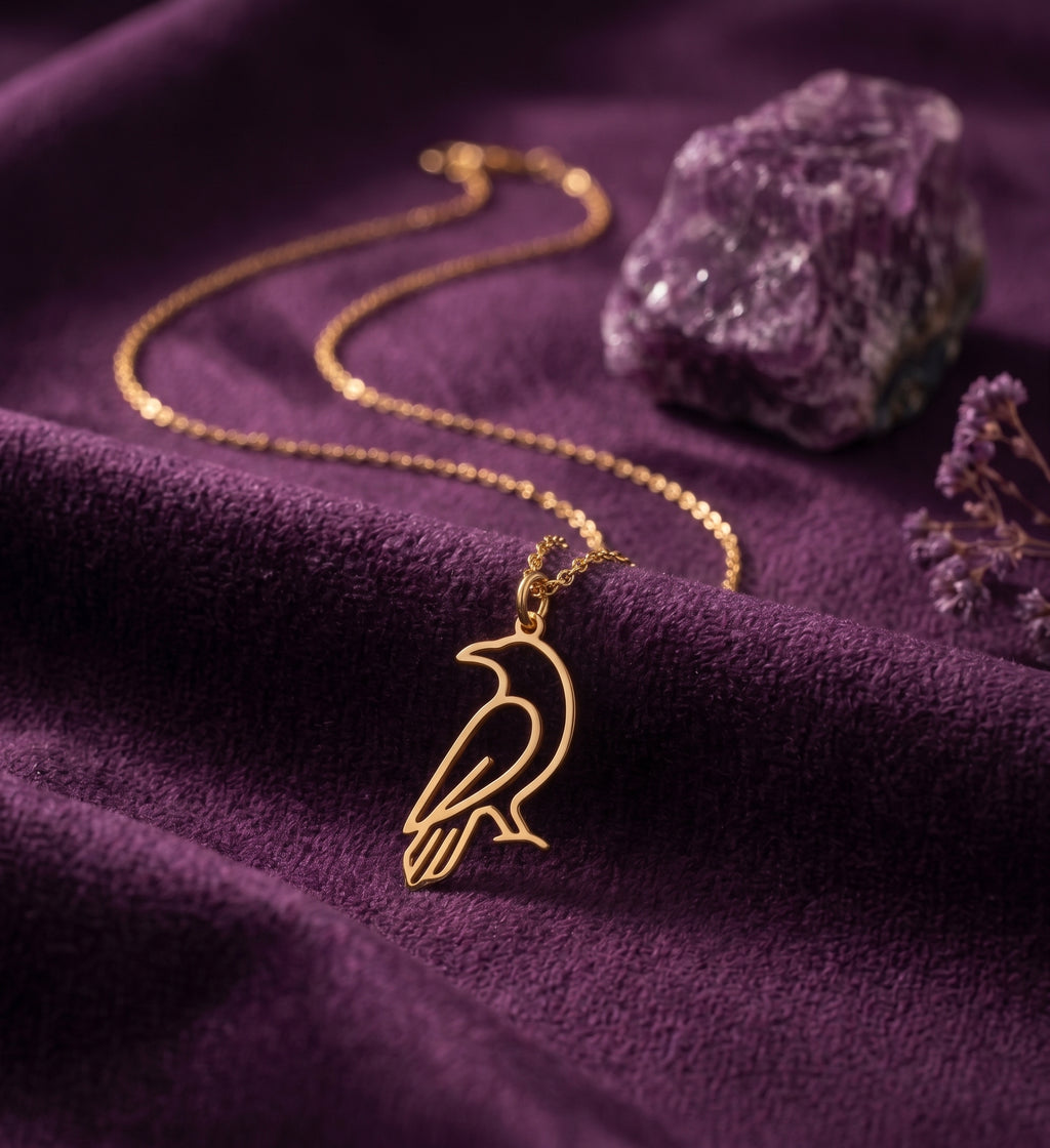 Close-up of the crow outline pendant on purple velvet