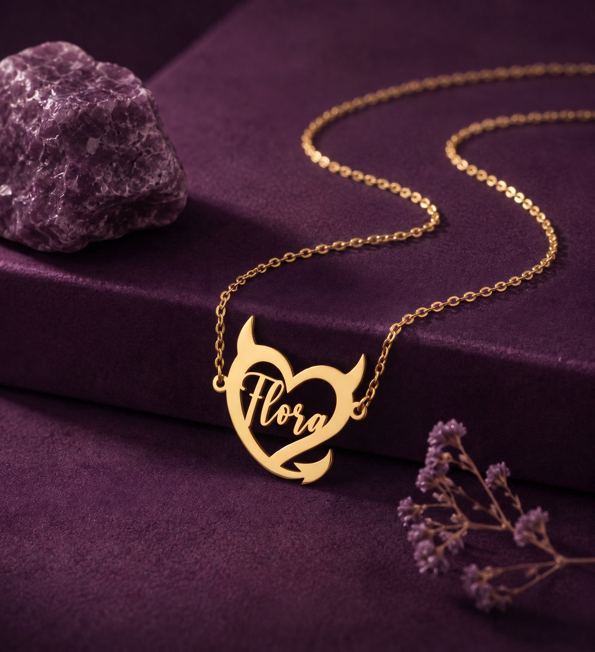 Devil heart name necklace on a plum box beside an amethyst stone