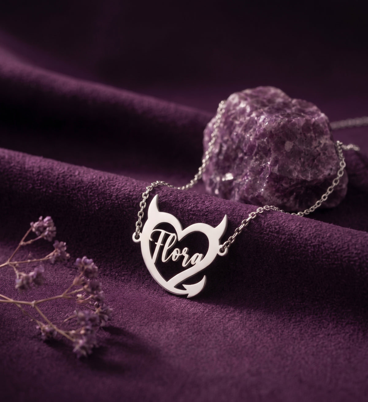 Silver tone devil heart name necklace on purple velvet