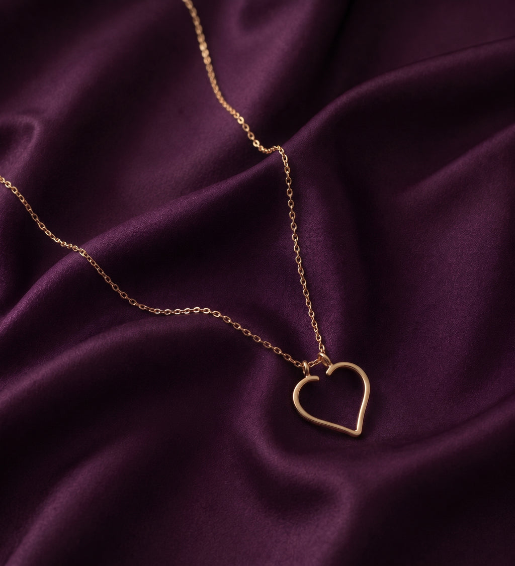 Heart ring holder necklace laid on purple satin