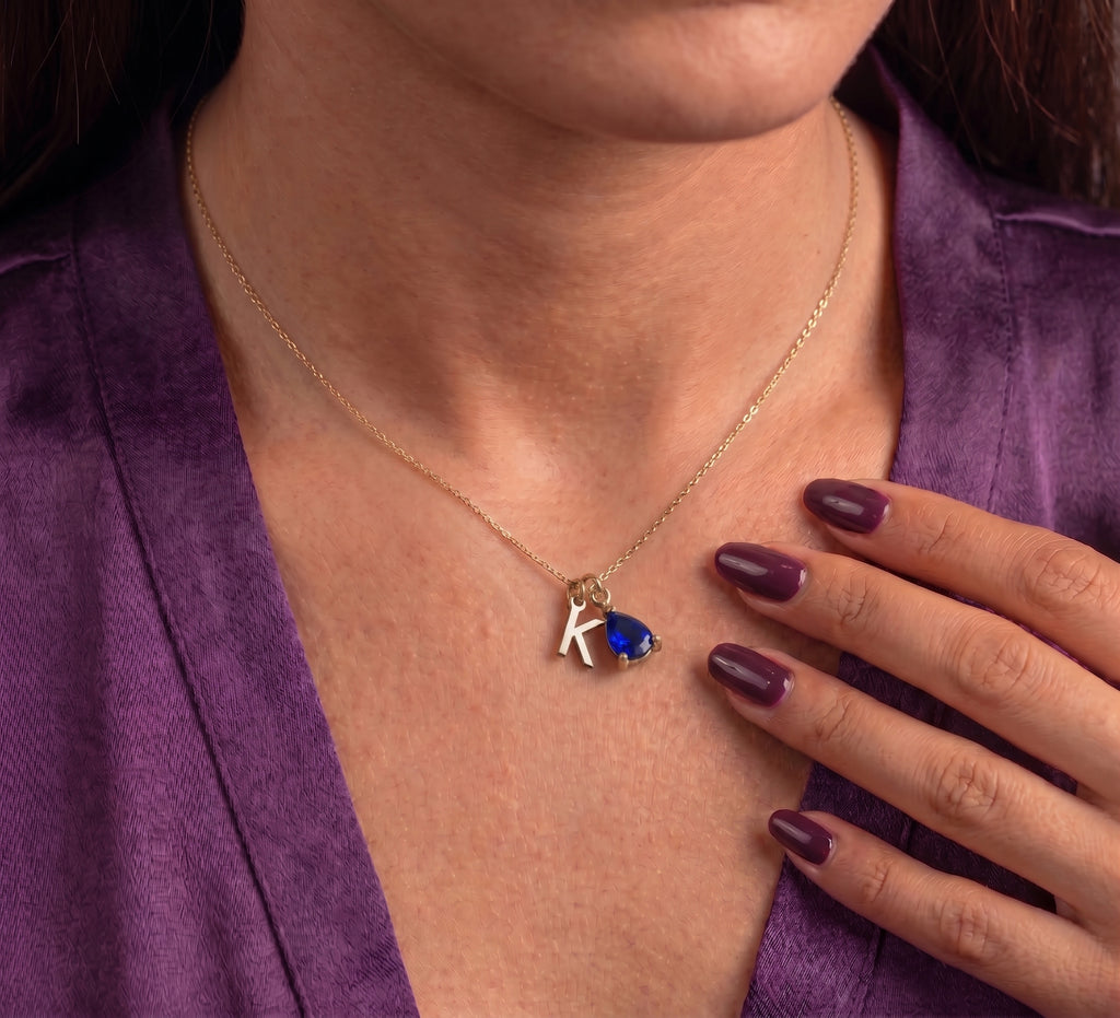 Initial and birthstone necklace worn, close-up