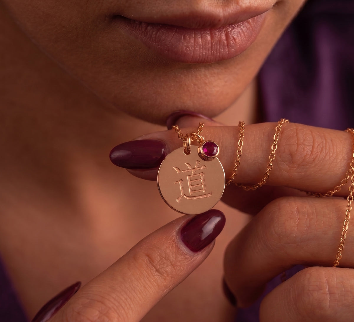 Kanji disc and stone charm held between the fingers