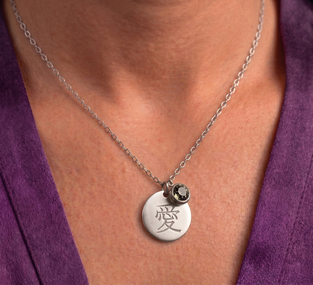 Silver tone kanji disc necklace worn, close-up