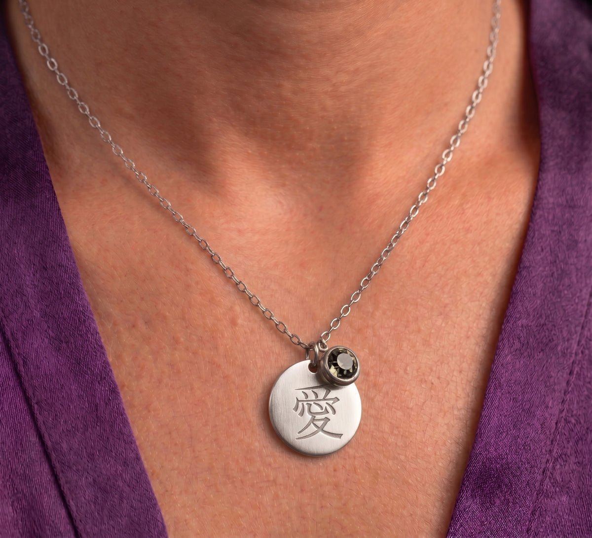 Silver tone kanji disc necklace worn, close-up