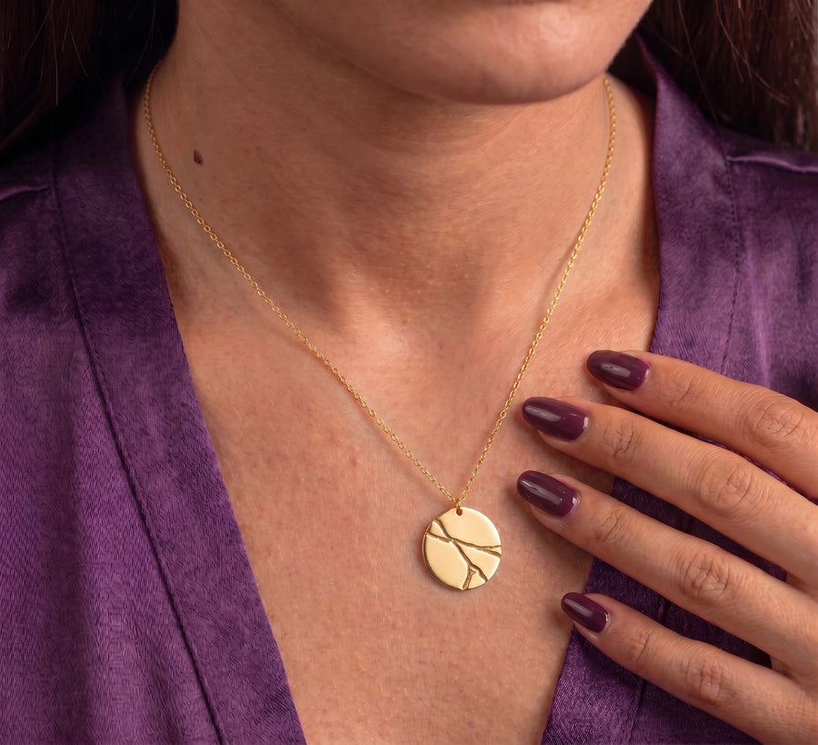 Kintsugi disc necklace worn on the chest