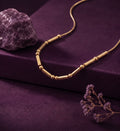 Morse code necklace with beads and bars on purple velvet beside an amethyst stone