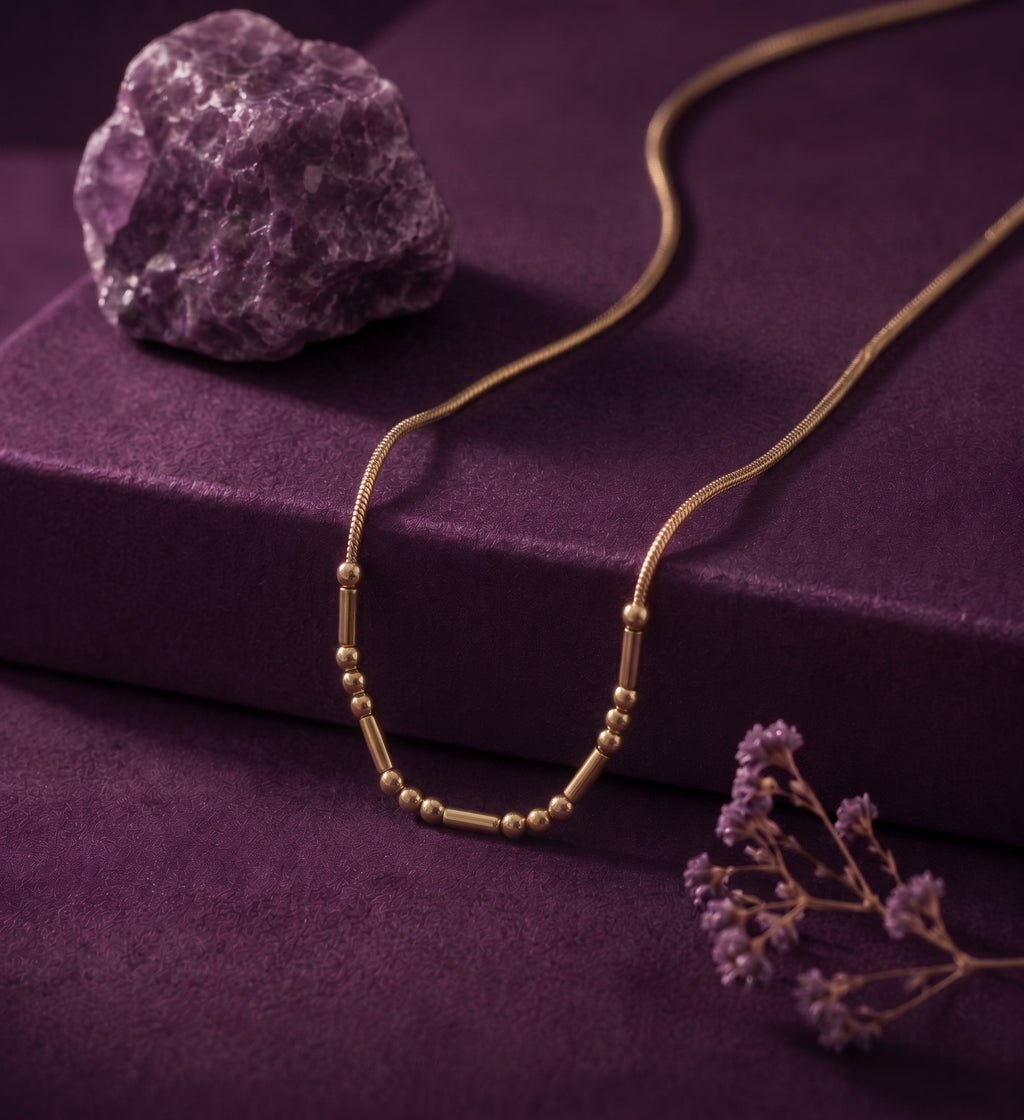 Morse code necklace on purple velvet with an amethyst stone